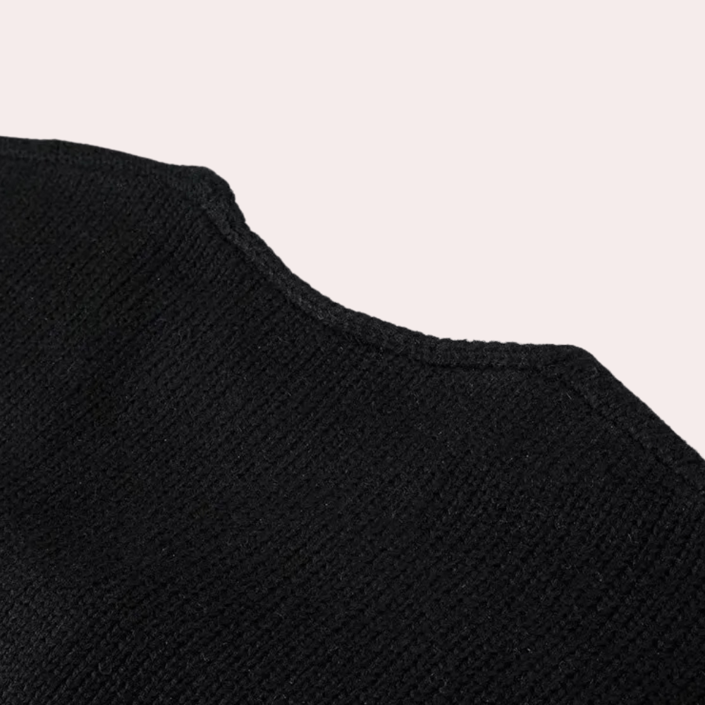 Zwarte gebreide trui detail, close-up van de stoftextuur. Hoogwaardige wol, modieuze kleding, comfortabele wintermode.