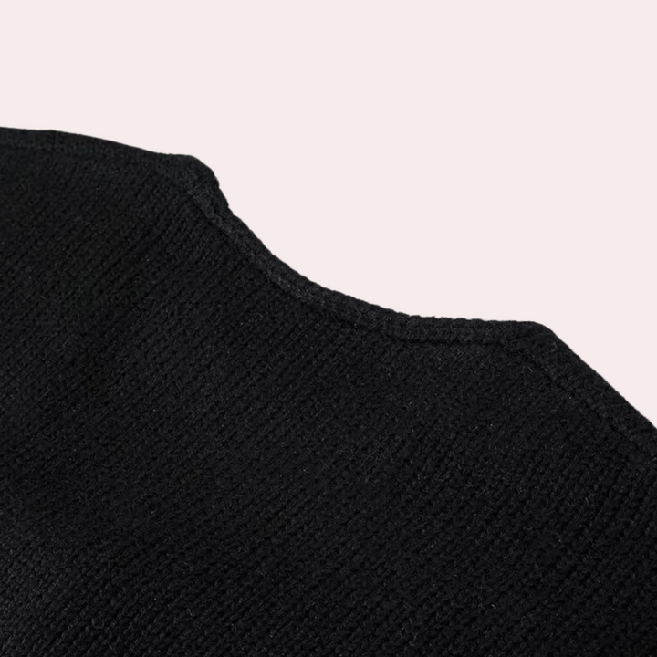 Zwarte gebreide trui detail, close-up van de stoftextuur. Hoogwaardige wol, modieuze kleding, comfortabele wintermode.