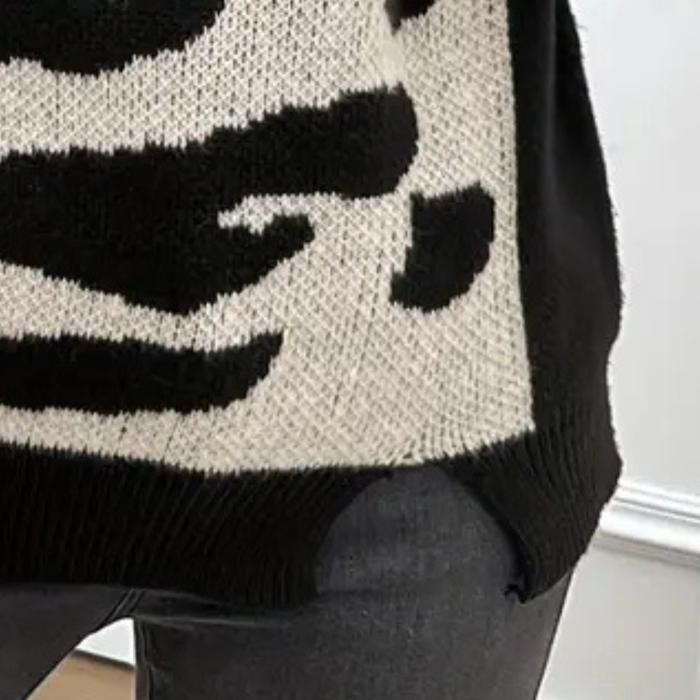 Zwart-witte dierenprint trui, gebreid patroon, modieuze dameskleding, close-up detail, trendy herfst- en wintermode, comfortabele stof.