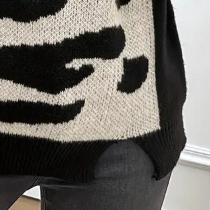 Zwart-witte dierenprint trui, gebreid patroon, modieuze dameskleding, close-up detail, trendy herfst- en wintermode, comfortabele stof.