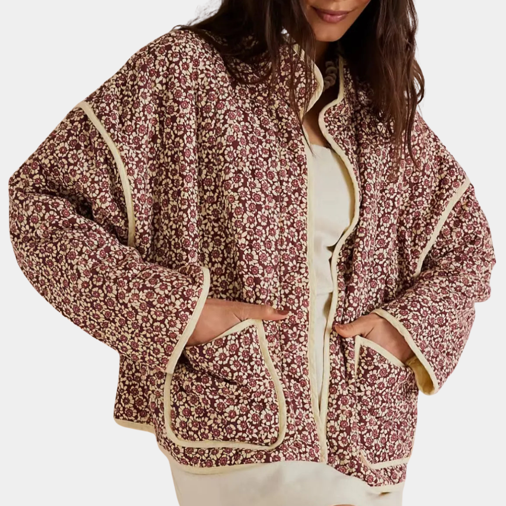 Vrouw draagt een bloemenprint jas met beige accenten, ideaal voor herfstmode. Stijlvolle dameskleding, comfortabele pasvorm, trendy design.