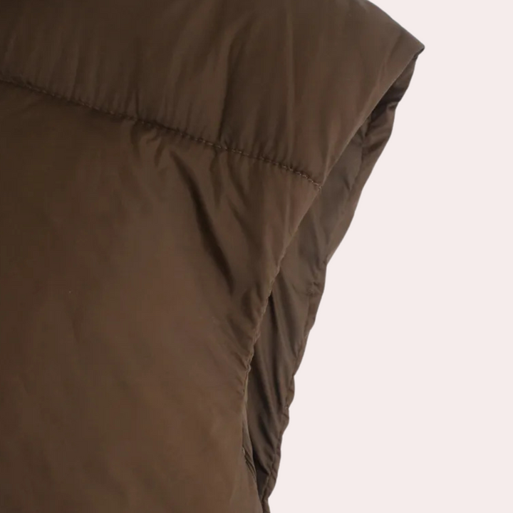 Donkerbruine gewatteerde jas, close-up van de schouder en mouw, modieuze winterkleding, warme isolatie, unisex design, casual stijl.