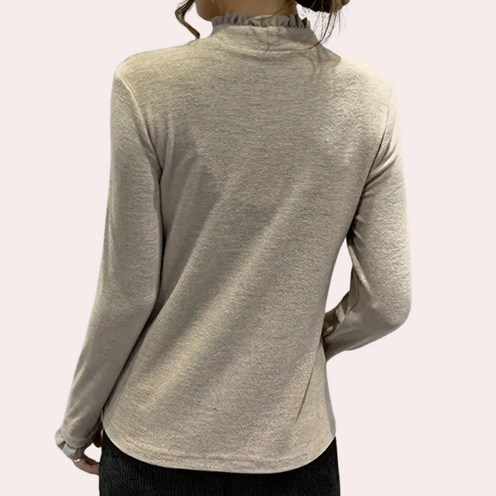Vrouw draagt beige coltrui met lange mouwen, geribbelde kraag en casual pasvorm. Perfect voor herfstmode en stijlvolle dameskleding.