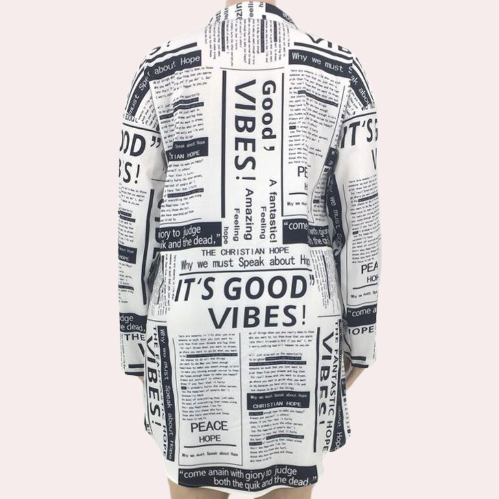 Witte jas met krantenprint, tekst "Good Vibes", lange mouwen, trendy mode, unisex design, casual stijl, opvallende kleding, streetwear.