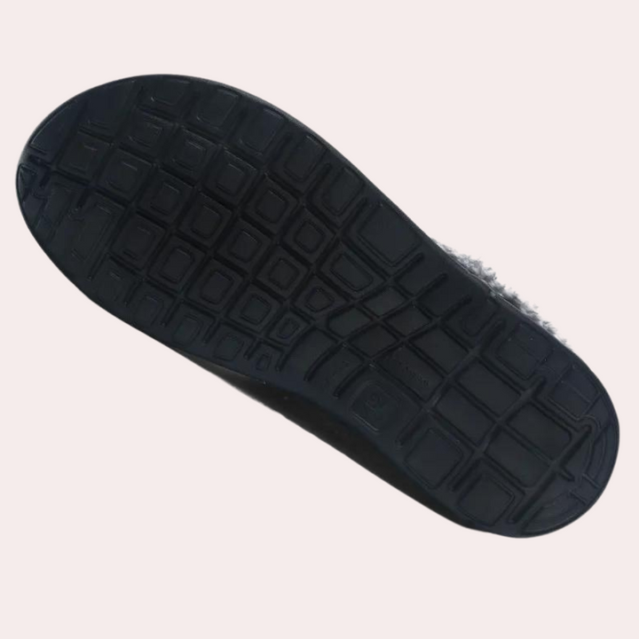Zwarte rubberen zool van een schoen met antislip patroon, geïsoleerd op een witte achtergrond. Perfect voor grip en duurzaamheid.