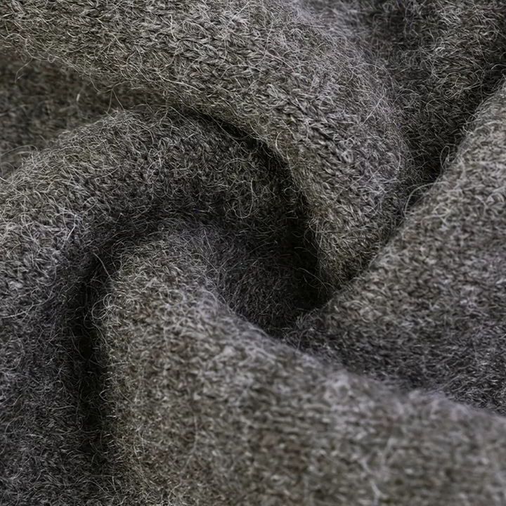 Grijze wollen stof close-up, textuur van gebreide wol, zachte en warme textielmaterialen, ideaal voor winterkleding en breiprojecten.