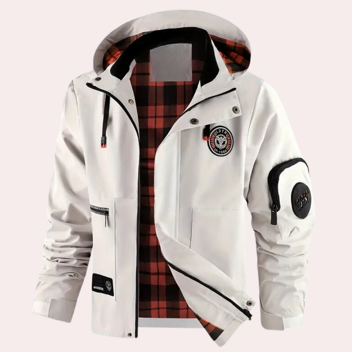 Witte herenjas met capuchon, rood geruite voering en meerdere zakken, inclusief mouwzak met rits. Ideaal voor outdoor activiteiten en casual stijl.