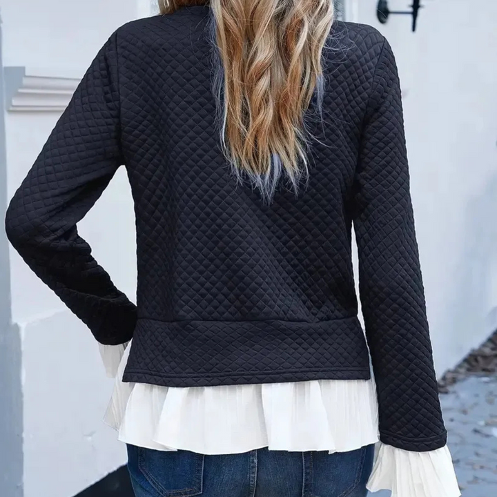 Vrouw in zwarte gewatteerde jas met witte ruches blouse, casual mode, herfstkleding, rugaanzicht, trendy dameskleding, stedelijke stijl.