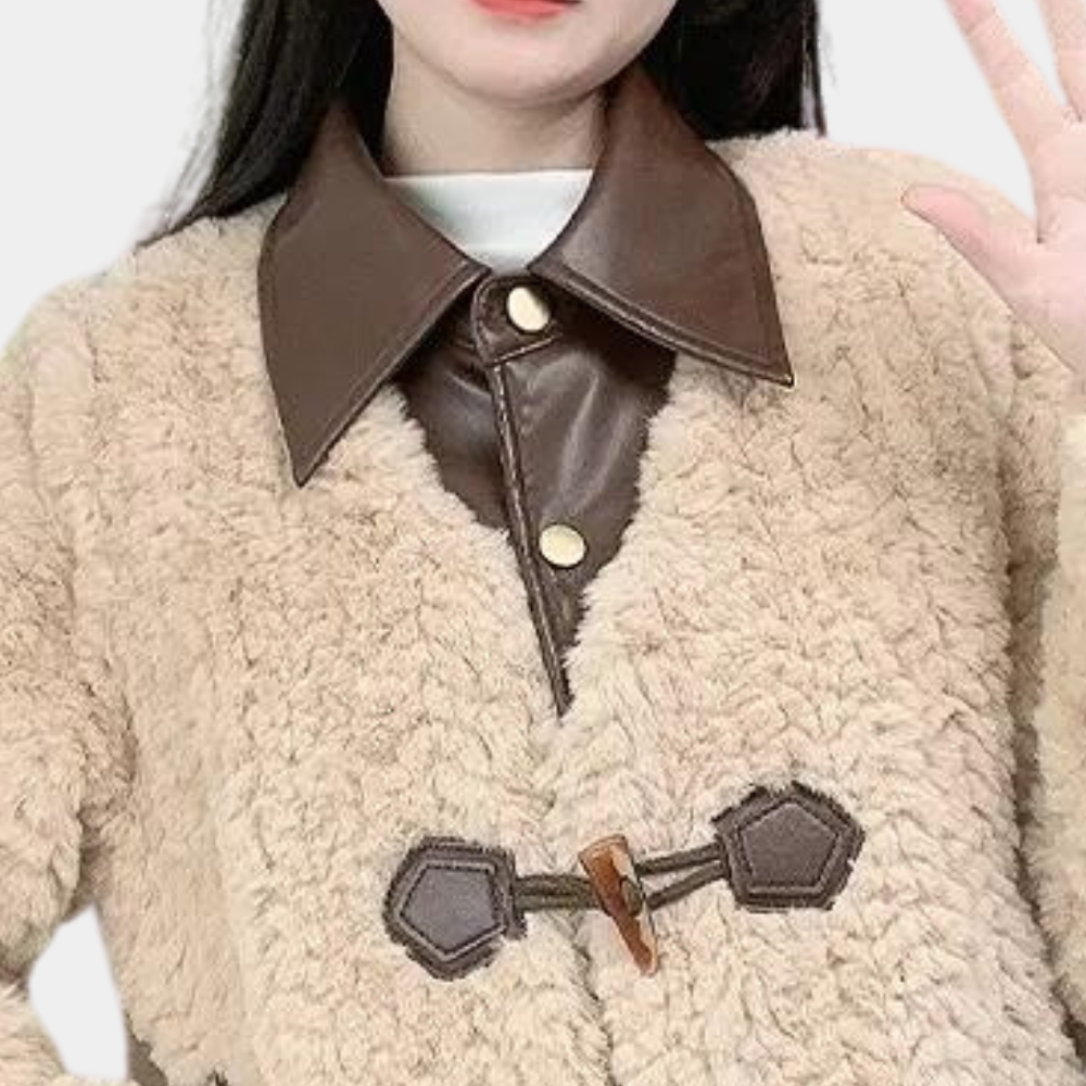 Vrouw in beige teddyjas met bruine leren kraag en knopen, modieuze winterkleding, trendy damesjas, warme en stijlvolle outfit.