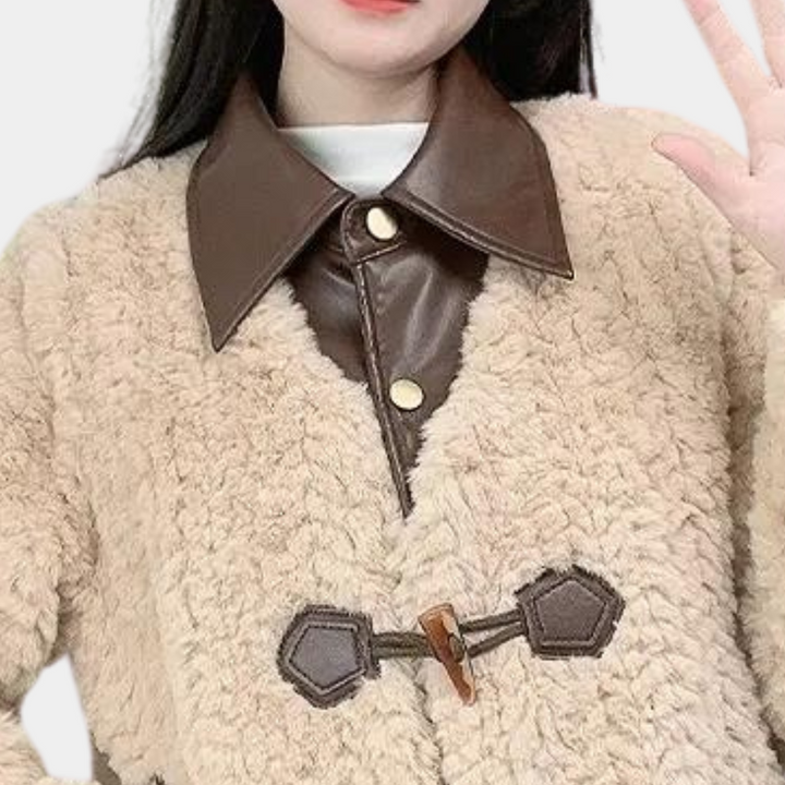 Vrouw in beige teddyjas met bruine leren kraag en knopen, modieuze winterkleding, trendy damesjas, warme en stijlvolle outfit.