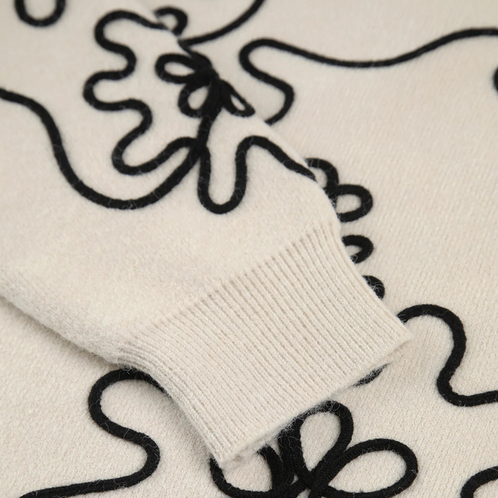 Crèmekleurige trui met zwarte abstracte lijnen, gebreide manchetten, moderne mode, comfortabele winterkleding, stijlvolle damestrui.