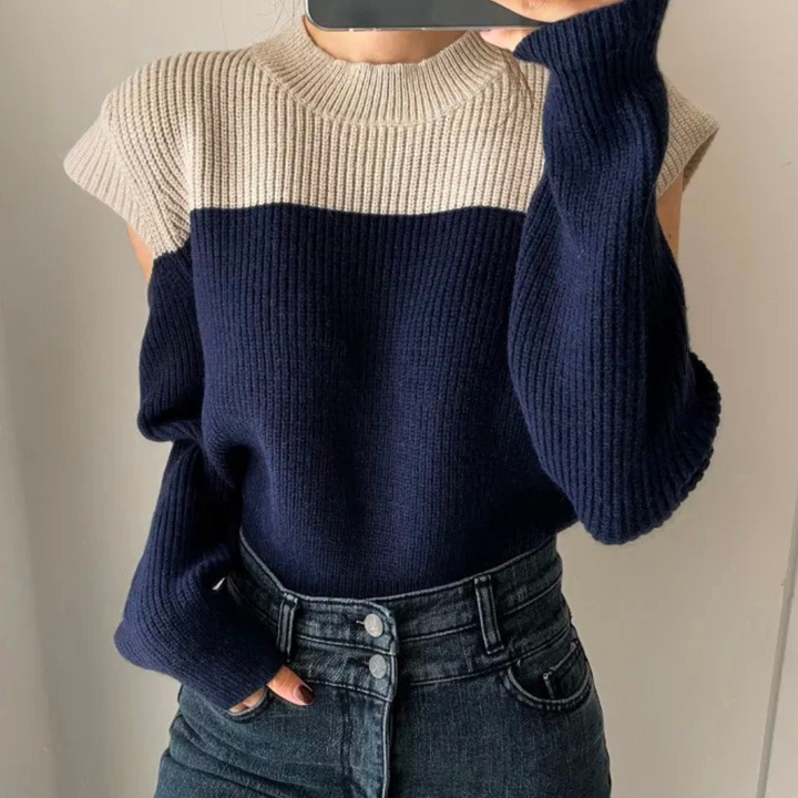 Damestrui met lange mouwen, kleurblok ontwerp in beige en donkerblauw, gecombineerd met high-waisted jeans. Stijlvolle herfst- en wintermode.