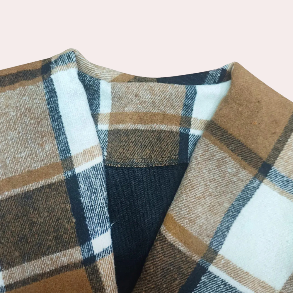 Bruin geruite wollen sjaal met zwart-witte strepen, close-up. Modieuze winteraccessoire, warme en stijlvolle sjaal voor koude dagen.