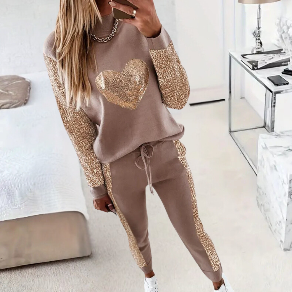 Vrouw in beige loungepak met gouden pailletten hart en mouwen, comfortabele mode, trendy dameskleding, stijlvolle huisoutfit, moderne slaapkamer.