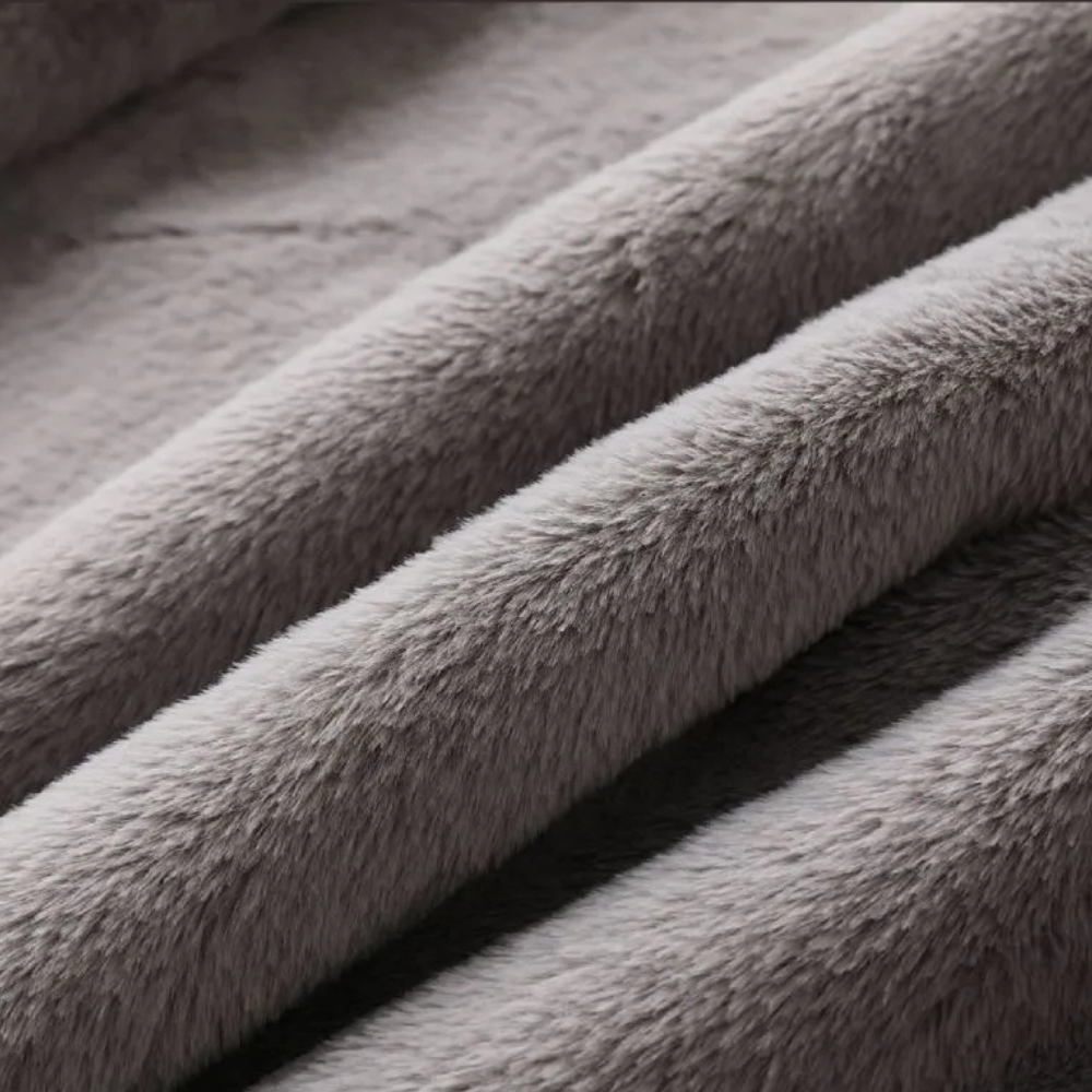 Grijze pluche stof close-up, zachte textuur, ideaal voor dekens en kleding. Hoogwaardige fleece stof, comfortabel en warm, perfect voor wintergebruik.