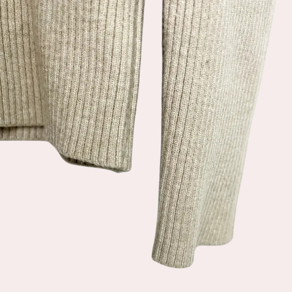 Beige geribbelde trui, close-up van mouw en zoom, zachte stof, modieuze dameskleding, herfst- en wintermode, casual stijl.