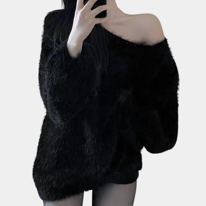 Vrouw in zwarte, off-shoulder, pluizige trui maakt selfie. Modieuze winterkleding, trendy oversized stijl, casual outfit.