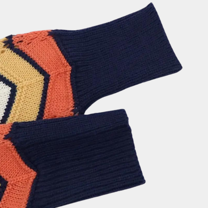 Gebreide trui met geometrisch patroon in oranje, blauw en wit, close-up van mouw en kraag, modieuze herenkleding, wintermode.