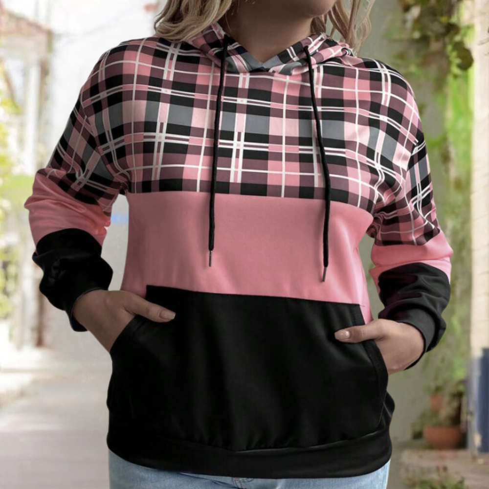 Vrouw in roze-zwart geruite hoodie met capuchon en buidelzak, casual mode, buitenomgeving. Perfect voor herfst- en winterkleding.