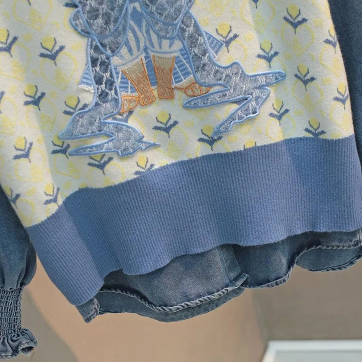 Gebreide trui met blauw en geel patroon, gedetailleerd borduurwerk en denim accenten. Modieuze dameskleding, herfstcollectie 2023.