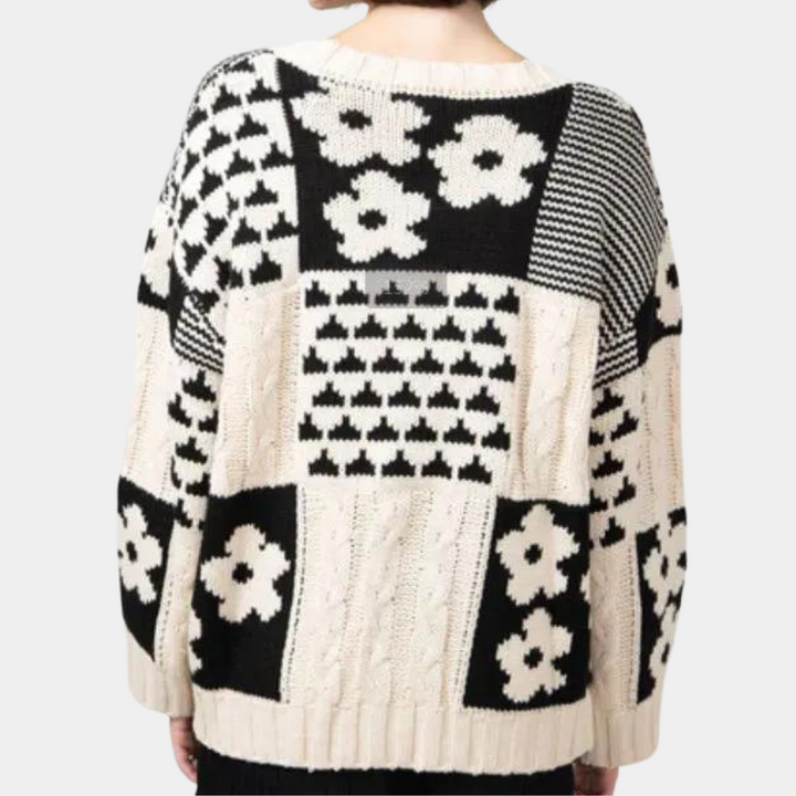 Zwart-witte gebreide trui met bloemen- en geometrisch patroon, oversized pasvorm. Modieuze dameskleding, herfst-winter stijl.