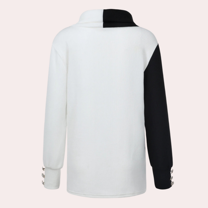 Witte en zwarte trui met lange mouwen, asymmetrisch ontwerp, knoopdetails op de mouwen. Modieuze dameskleding, herfst-winter collectie.