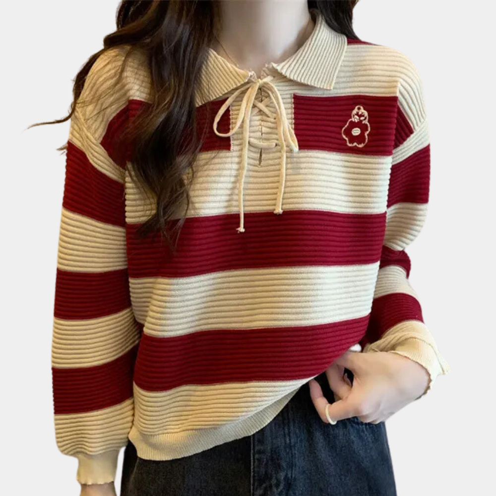 Vrouw draagt gestreepte trui met rode en beige strepen, kraag met striksluiting en bloemapplicatie, casual mode, herfstkleding, trendy dameskleding.