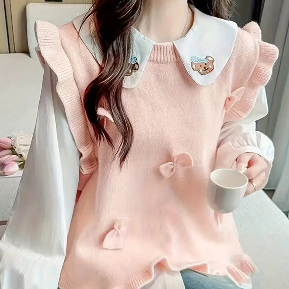 Vrouw in roze trui met ruches en schattige kraag, drinkt koffie. Modieuze dameskleding, casual outfit, trendy herfststijl.