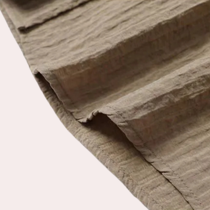 Beige katoenen stof met geribbelde textuur, close-up. Ideaal voor kleding, interieurdecoratie en ambachtelijke projecten. Hoogwaardige textielmaterialen.