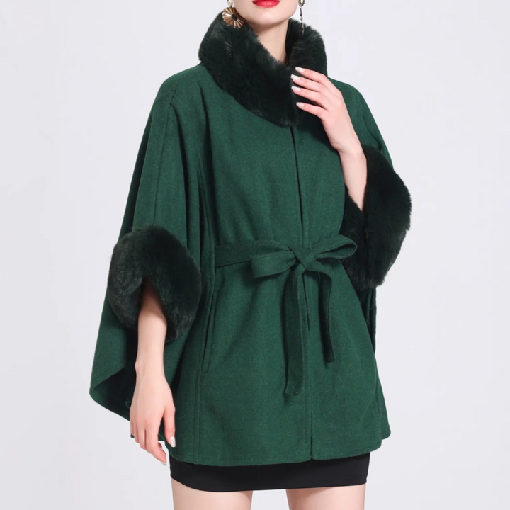 Groene damescape met zwarte bontkraag en manchetten, strikceintuur, elegante wintermode, stijlvolle jas, warme dameskleding.