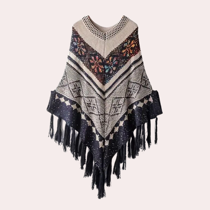 Boho poncho met kleurrijk bloemenpatroon, geometrische motieven en franjes. Perfect voor herfstmode en bohemian stijl.