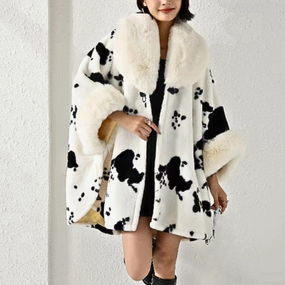Vrouw in stijlvolle zwart-witte bontjas met koeienprint, modieuze winterkleding, trendy damesmode, warme jas voor koude seizoenen.