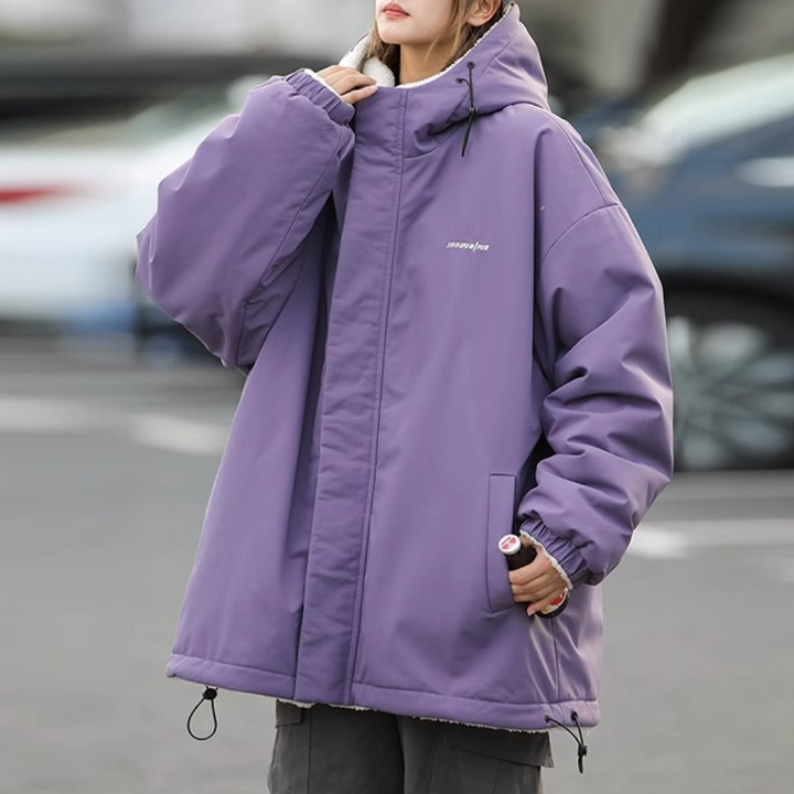 Paarse oversized winterjas met capuchon, gedragen door persoon op straat. Modieuze, warme jas voor dames, ideaal voor koude seizoenen.