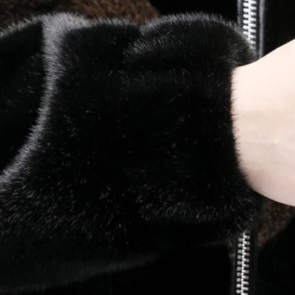 Zwarte bontjas met rits, close-up van mouw en hand. Luxe wintermode, warme kleding, stijlvolle damesjas, hoogwaardige materialen.