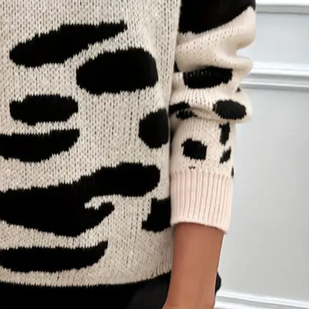 Zwart-witte trui met abstracte dierenprint, gebreid patroon, lange mouwen. Modieuze dameskleding, herfst-winter stijl, casual outfit.