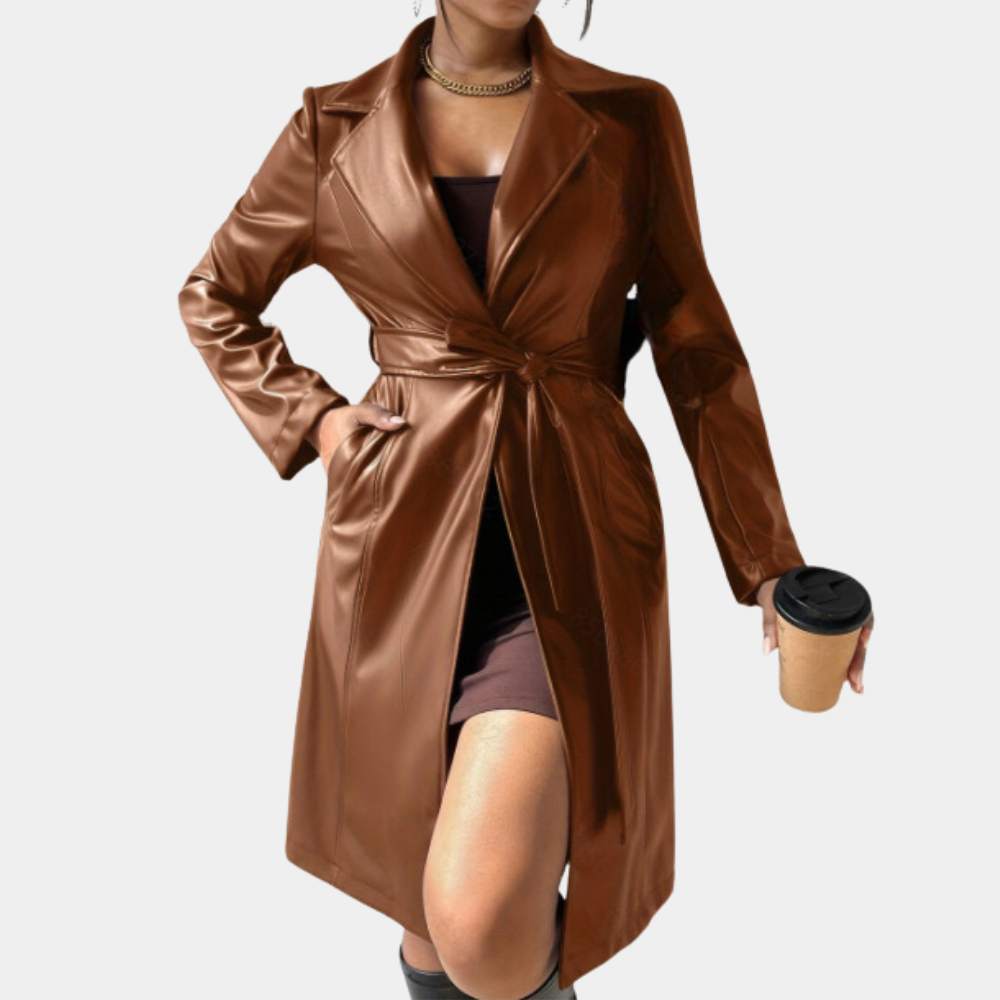 Vrouw in bruine leren trenchcoat met ceintuur, houdt een koffiebeker vast. Modieuze herfstjas, dameskleding, stijlvolle buitenkleding.