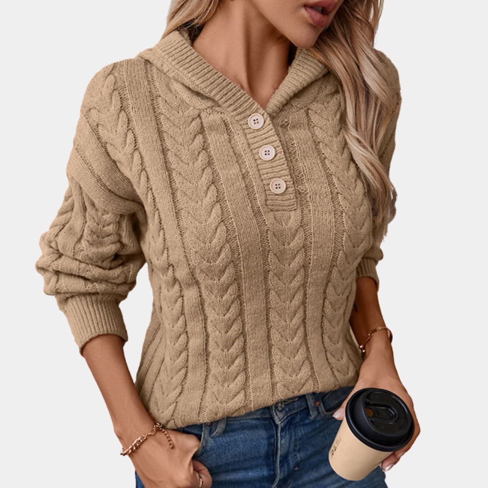 Vrouw in beige kabeltrui met capuchon en knopen, houdt een koffiebeker vast. Modieuze herfstkleding, casual stijl, comfortabele pasvorm.