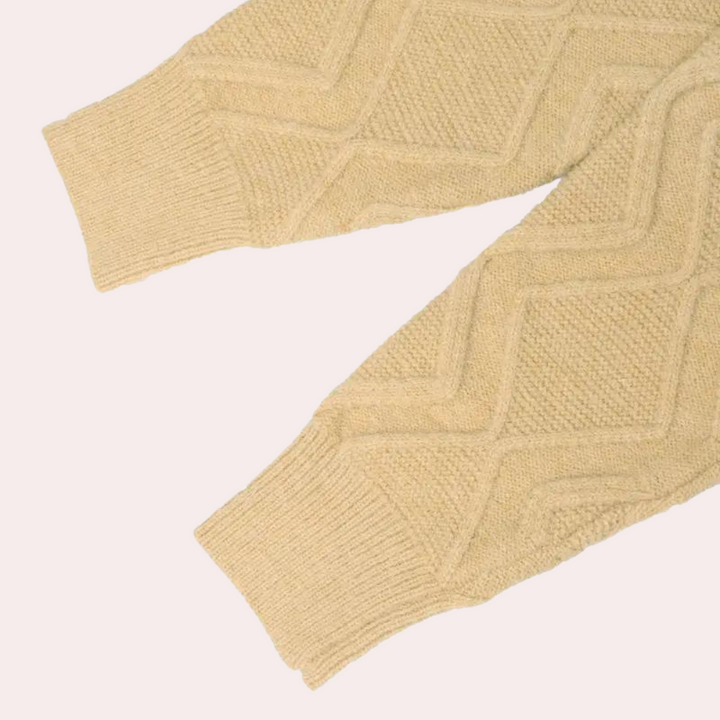 Beige gebreide trui met kabelpatroon, lange mouwen, textuur details. Perfect voor herfstmode, warme kleding, stijlvolle truien.