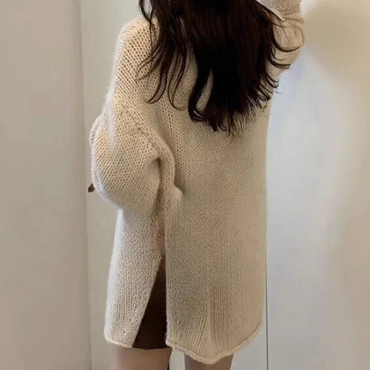 Vrouw in beige gebreide trui met lange mouwen, casual wintermode, comfortabele dameskleding, trendy oversized stijl, achterkant zicht.