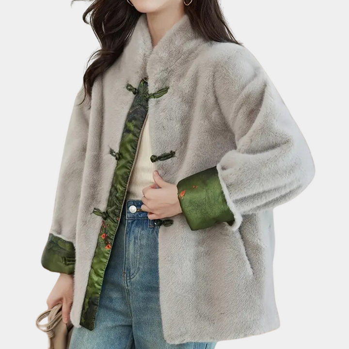 Grijze faux fur jas met groene satijnen voering en knopen, gedragen door vrouw. Modieuze winterjas, warme dameskleding, trendy stijl.