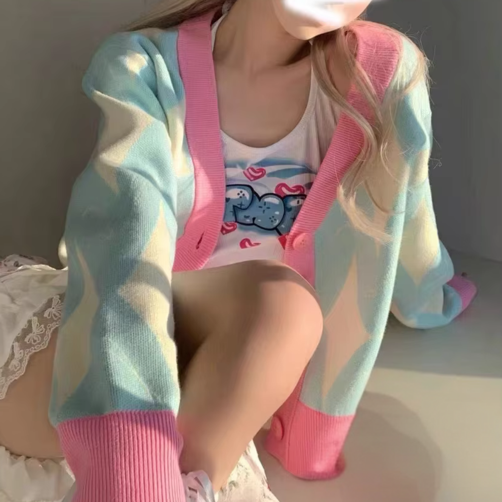 Vrouw in pastel gekleurde cardigan met geometrisch patroon, zittend in zonlicht. Trendy damesmode, casual lente outfit, zachte kleuren.