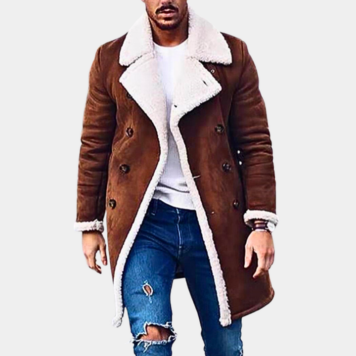 Bruine herenjas met witte schapenvachtkraag, dubbele rij knopen, gedragen met blauwe gescheurde jeans. Stijlvolle wintermode voor mannen.