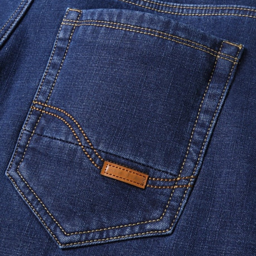 Blauwe denim jeanszak met oranje stiksels en leren label. Modieuze spijkerbroek, casual kleding, hoogwaardige stof, trendy design.