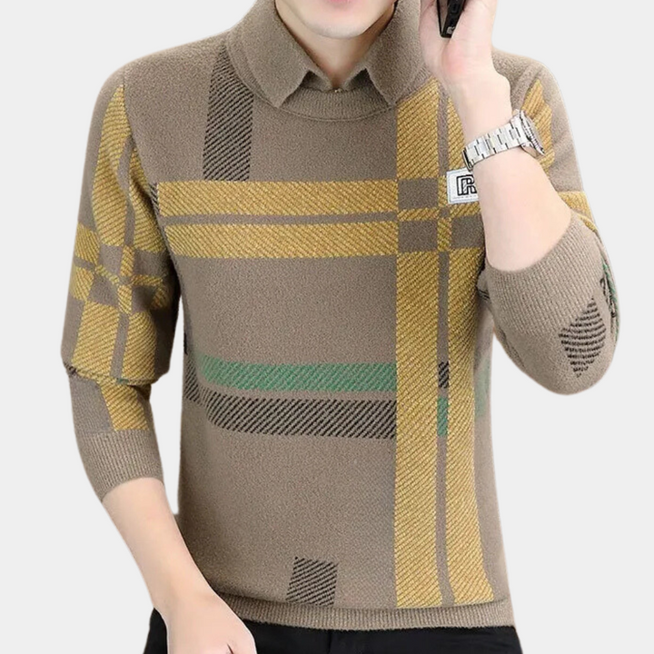 Man in beige trui met geruit patroon, lange mouwen en opstaande kraag, draagt horloge. Modieuze herenkleding, herfst/winter stijl.