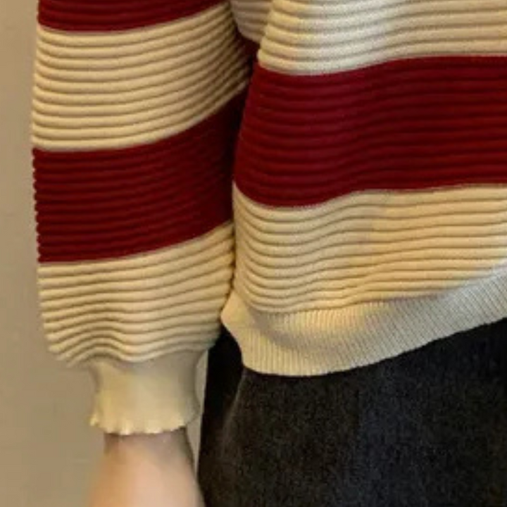 Gestreepte trui met rode en beige ribbels, gedragen door persoon. Modieuze gebreide kleding, herfst- en winterstijl, casual outfit.