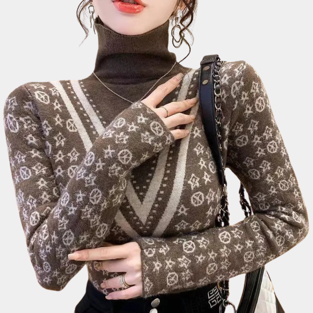 Vrouw draagt bruine coltrui met wit geometrisch patroon, ketting en zwarte schoudertas. Modieuze winterkleding, trendy damesmode.