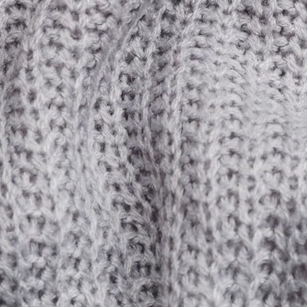 Grijze gebreide stof close-up, textuur van wol, geschikt voor winterkleding en interieurdecoratie, zachte en warme uitstraling.