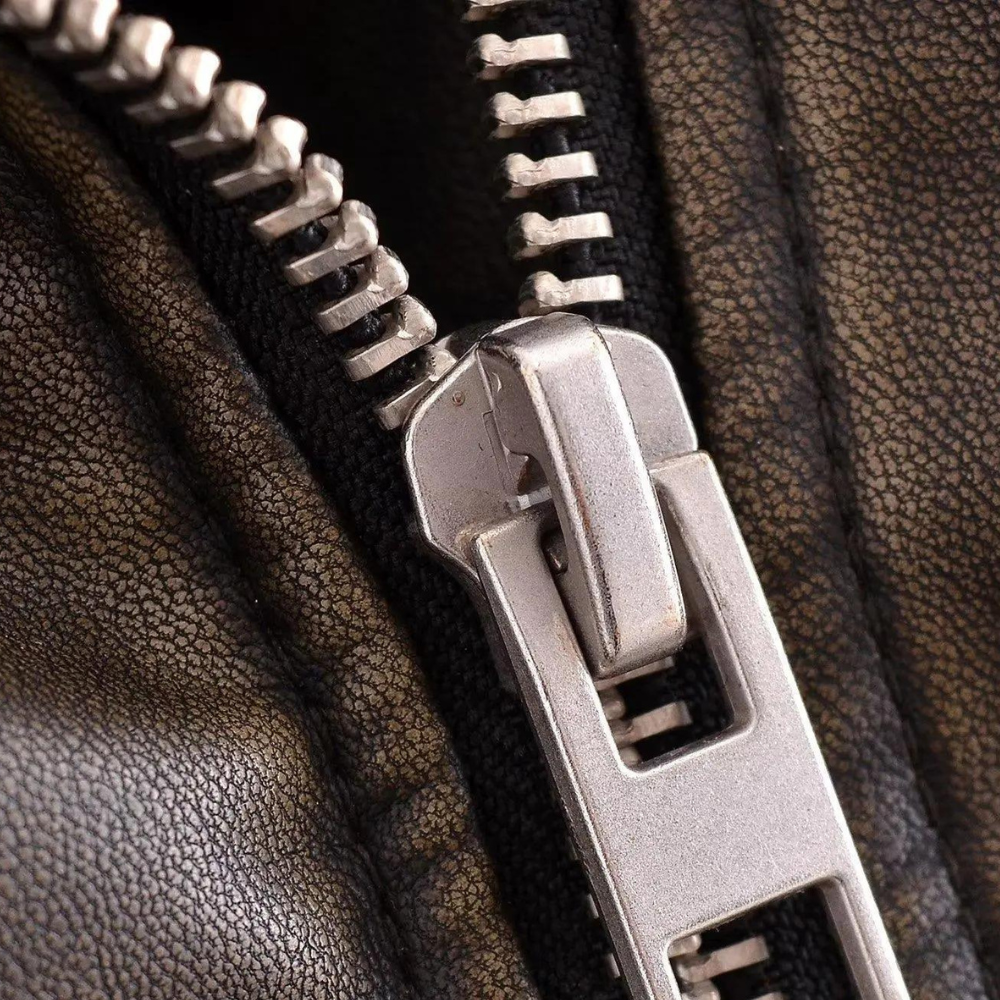 Close-up van een metalen ritssluiting op bruin leren jas, gedetailleerd textuur, modeaccessoire, hoogwaardige rits, duurzame kleding.