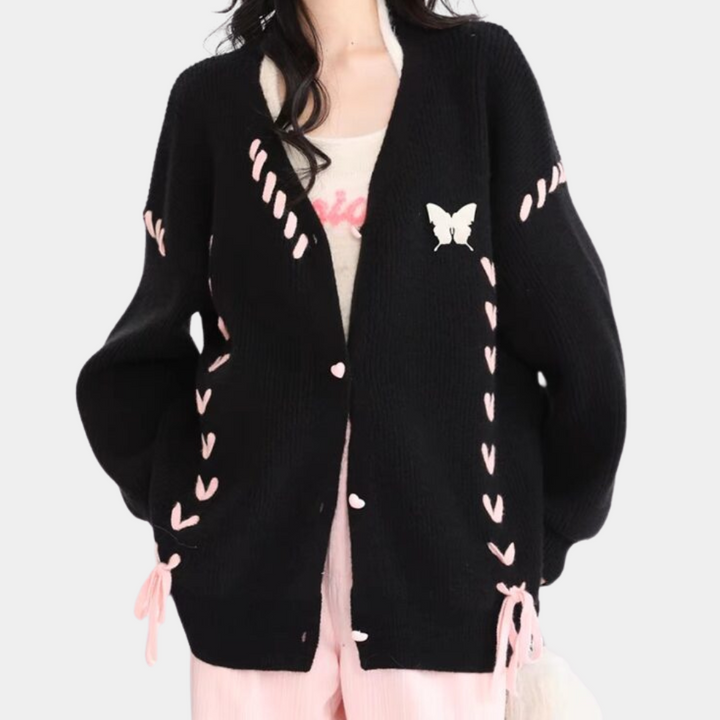 Zwarte gebreide cardigan met roze hartjes en vlinderapplicatie, damesmode, trendy herfstkleding, casual stijl, comfortabele pasvorm.
