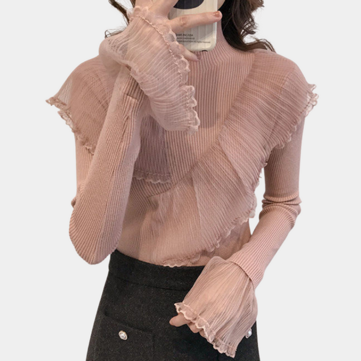 Vrouw in roze geribbelde trui met ruches, houdt smartphone vast. Modieuze dameskleding, herfsttrends, casual chique stijl.
